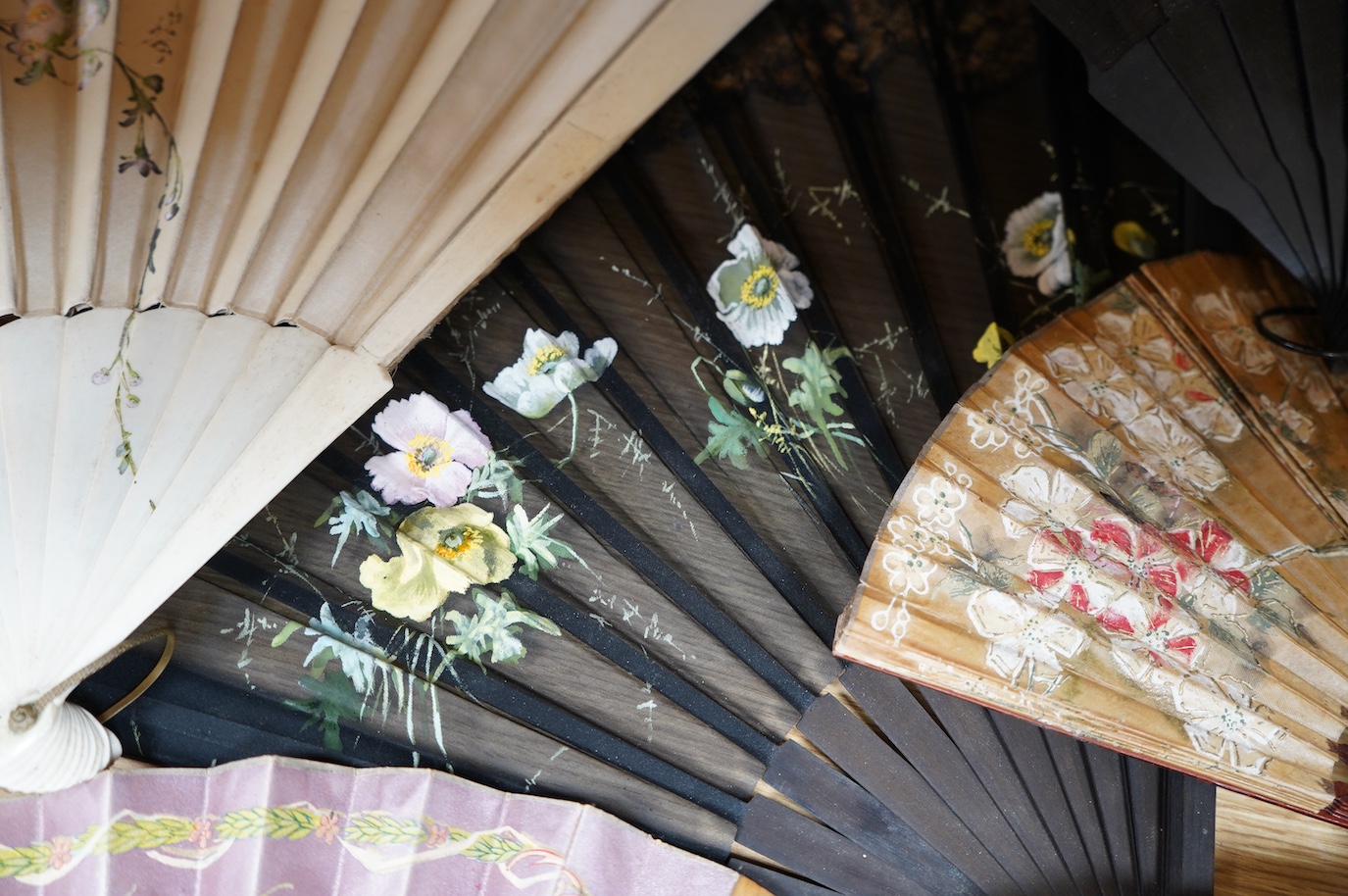 A group of 19th/20th century fans and two parasols, largest fan 33cm, (14). Condition - poor to fair.